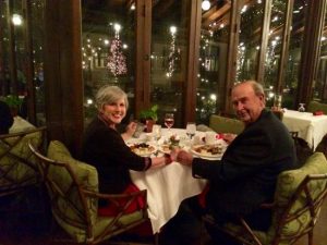 Senior couple holding hands at a table set for the holidays