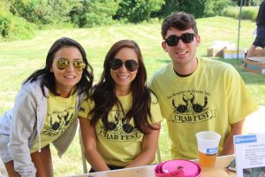 Three young people in Crab Fest t-shirts smiling at the camera